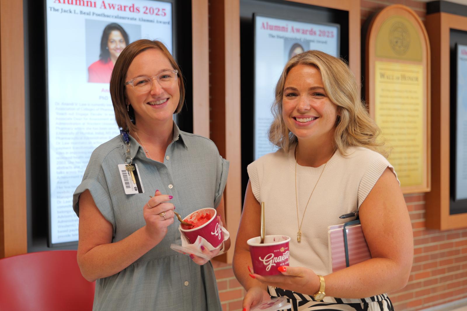 Two women smiling with their ice cream cups