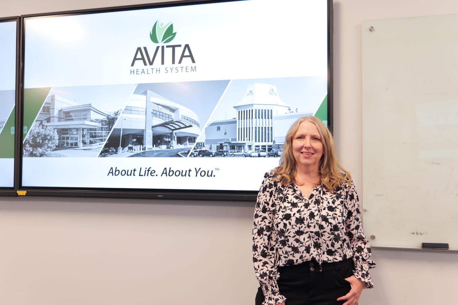 Dr. Barnes smiling in front of her introduction slide 
