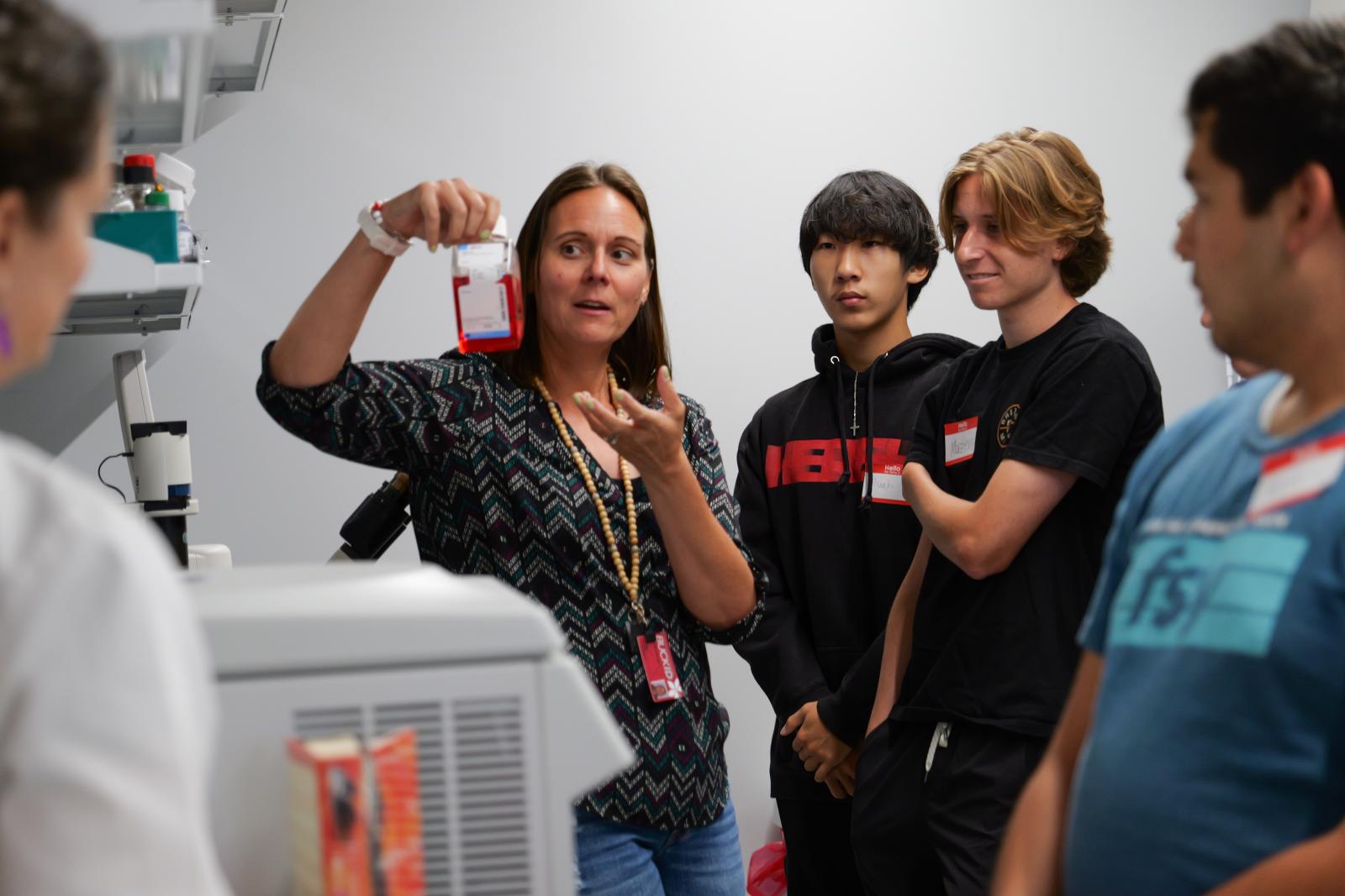 Research scientist Daelynn Buelow shows campers around the Experimental Cancer Pharmacology Lab (ECPL)