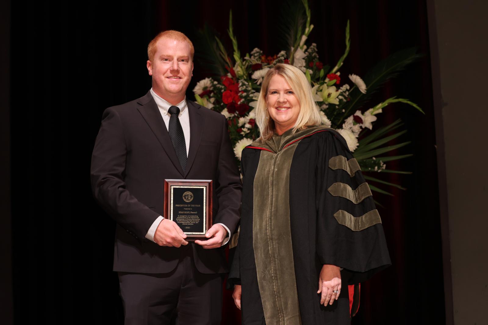 Dr. Riley receiving the Preceptor of the Year award, next to Dr. Legg