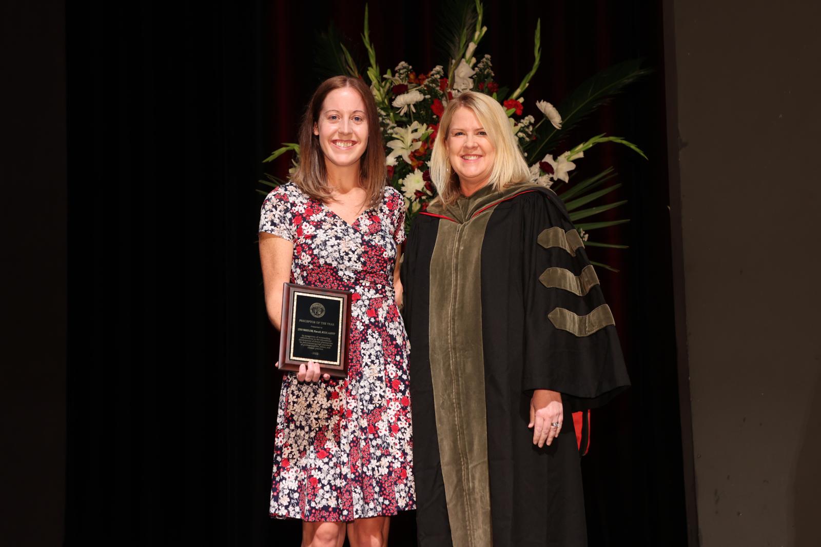 Dr. Wardlow receiving the Preceptor of the Year award, next to Dr. Legg