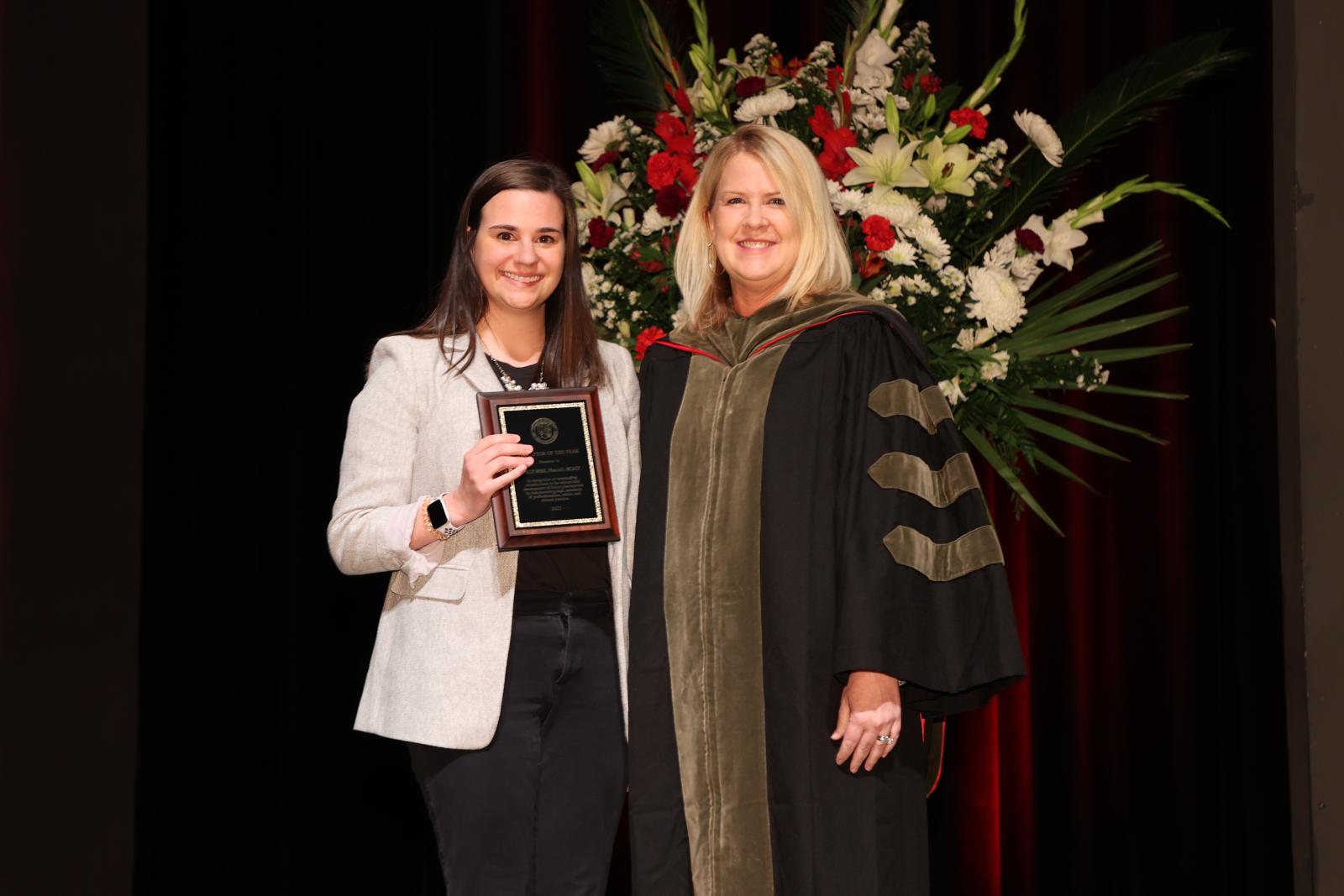 Dr. Wise receiving the Preceptor of the Year award, next to Dr. Legg