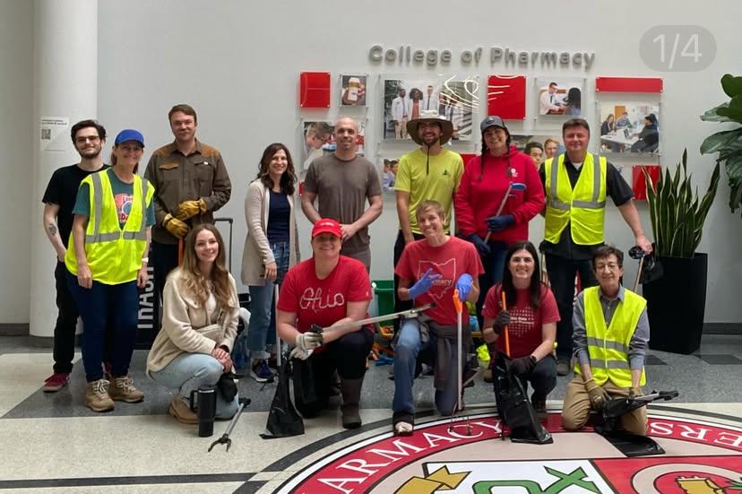 a group of people preparing to clean trash pose for a photo