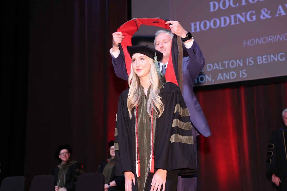 Dr. Jim Dalton hoods his daughter, Dr. Ava Dalton