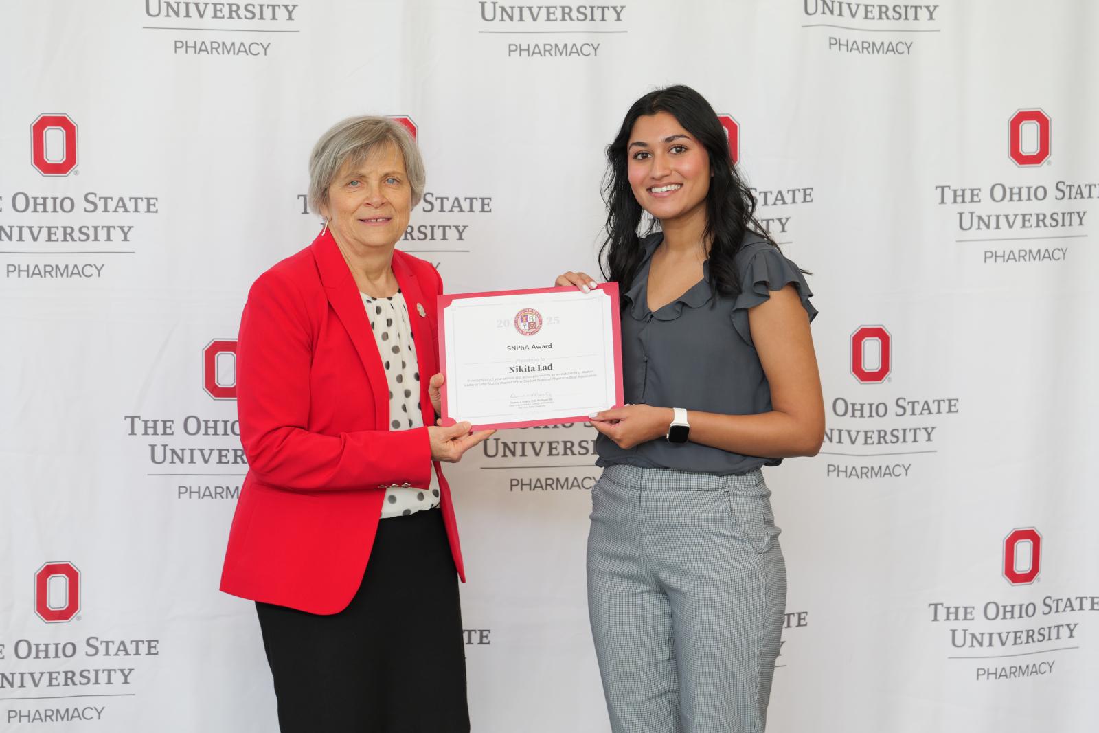dean and student hold a certificate