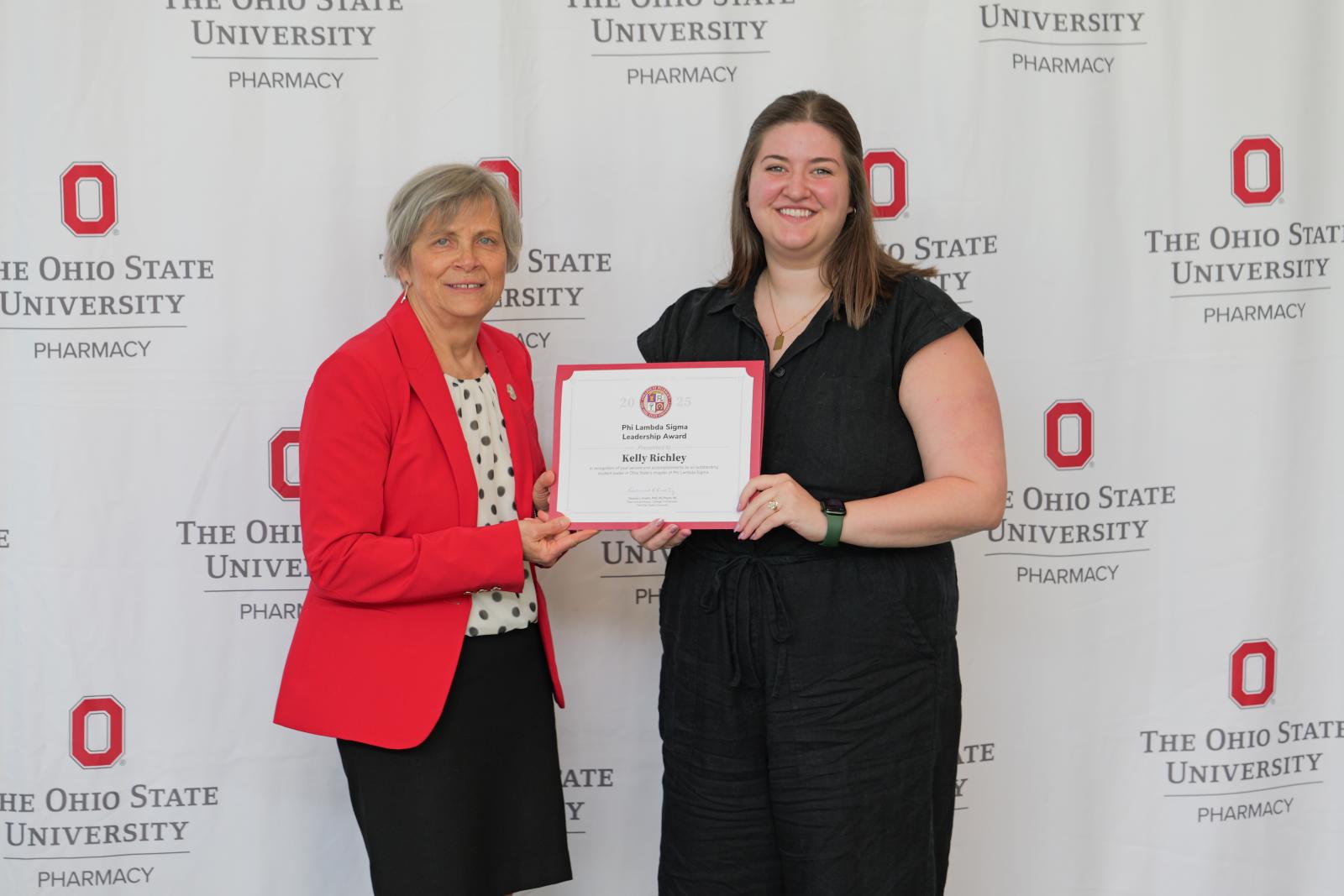 dean and student hold a certificate