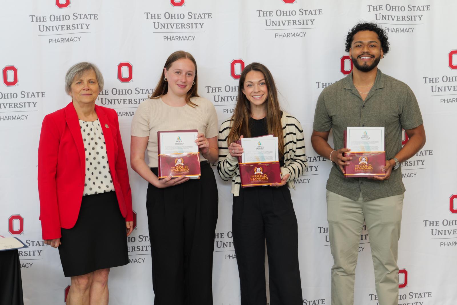 the dean and three students with certificates