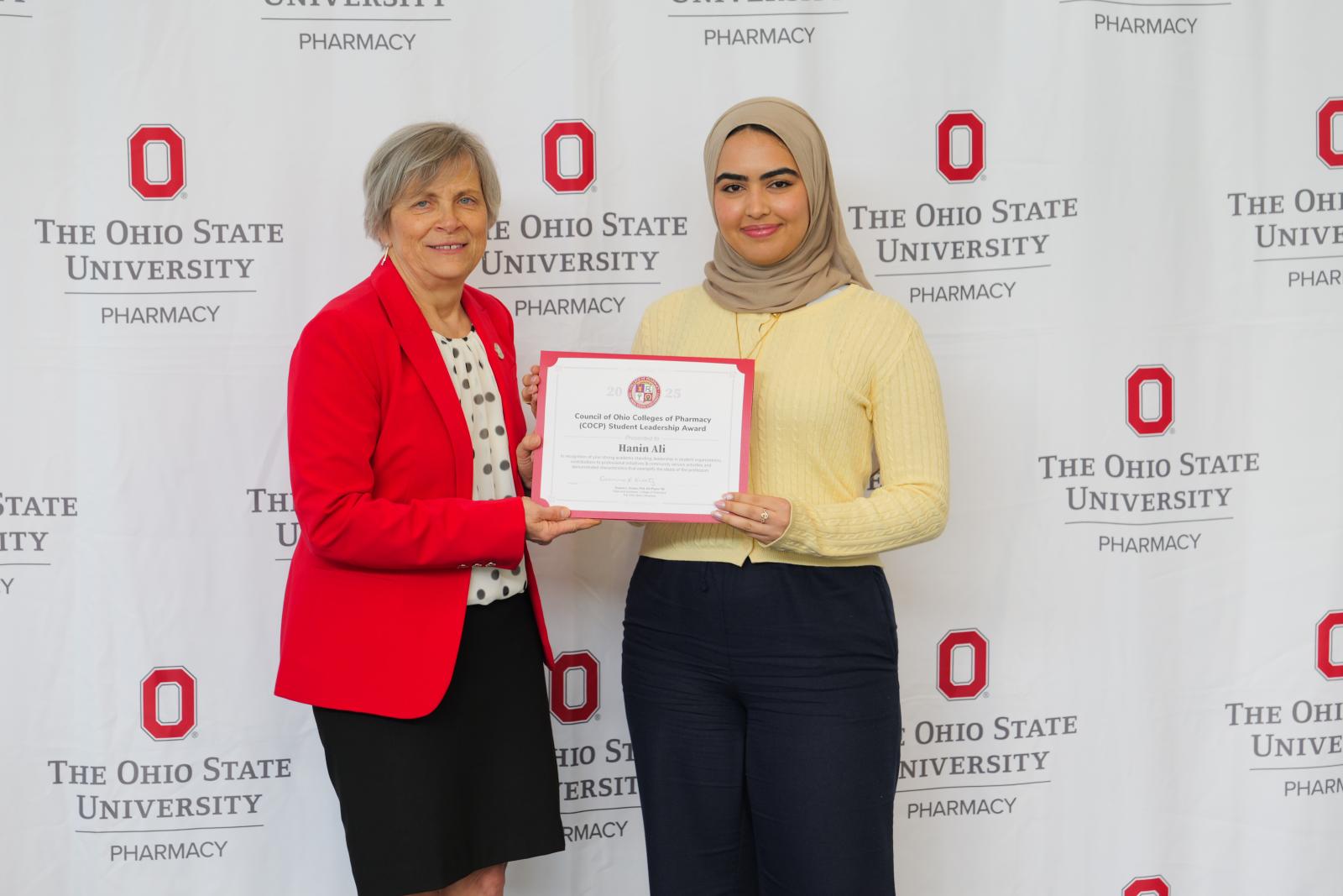 dean and student pose with a certificate
