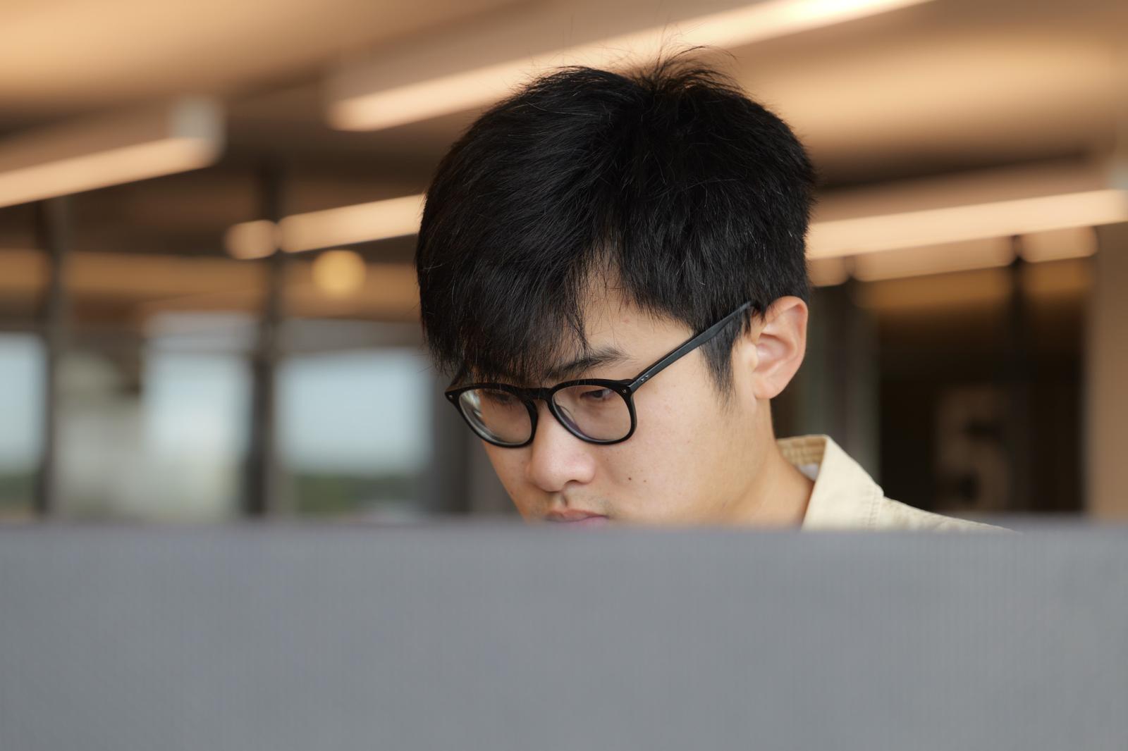sam xing looking at a computer monitor