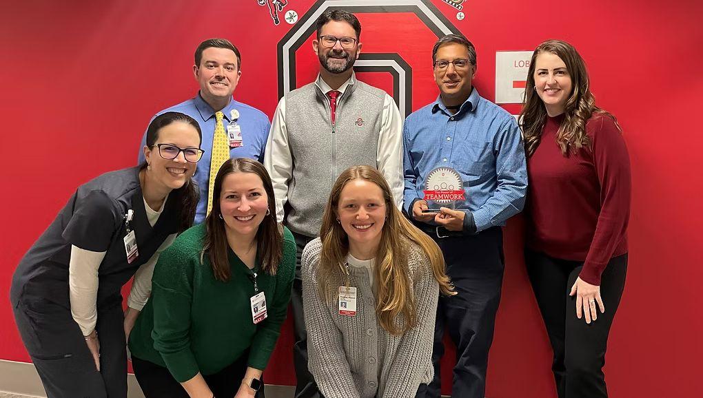 The General Internal Medicine pharmacy team posing for a photo with the "Power of Teamwork" OSUWMC award