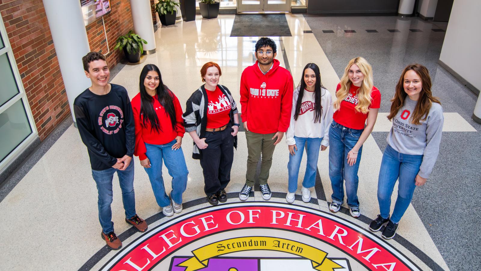 students standing around college seal