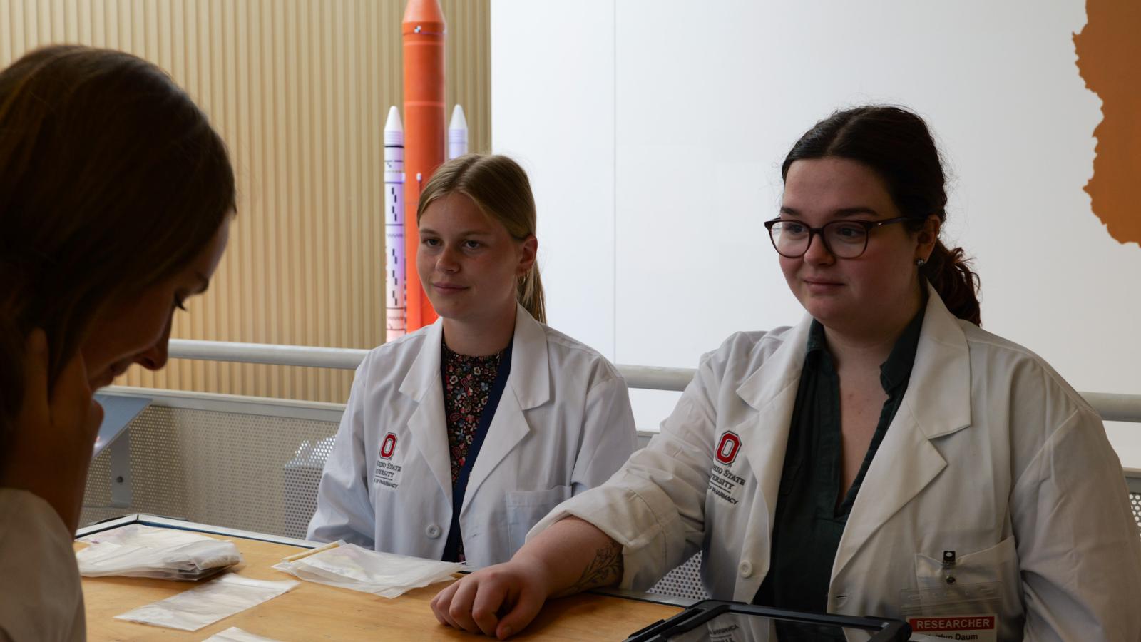 two students speaking with a guest