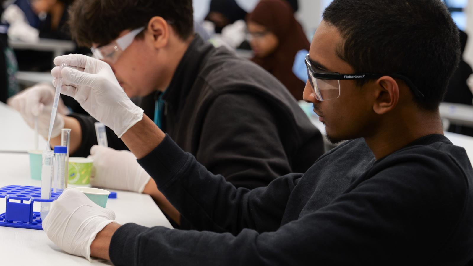 Student inspecting the contents of a vial