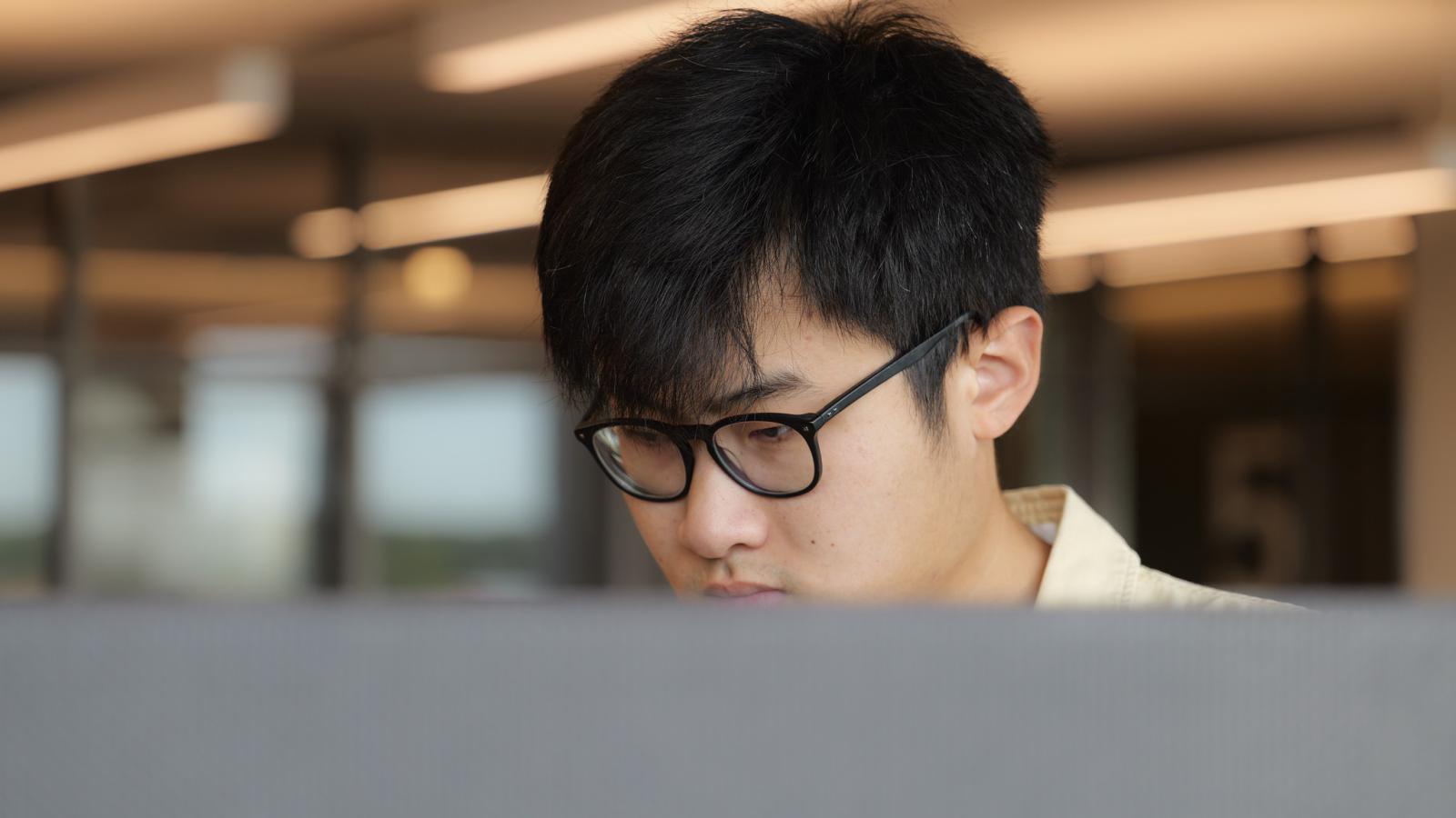 sam xing looking at a computer monitor