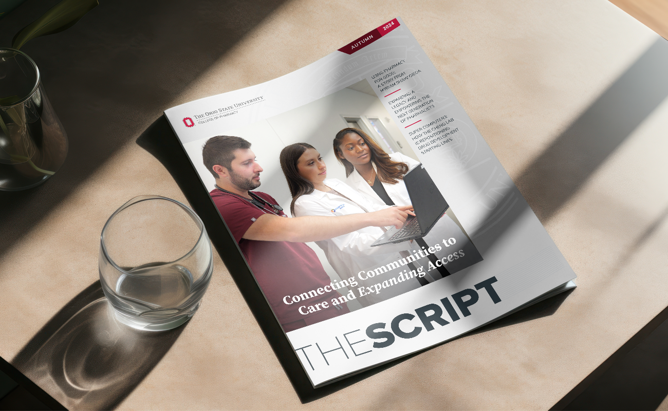 a copy of the script magazine on a table next to a glass of water