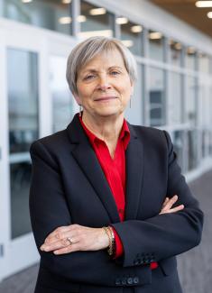 Photo of Dean Kroetz smiling with arms crossed in Vrable Classroom