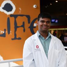 a student posing in the lab exhibit