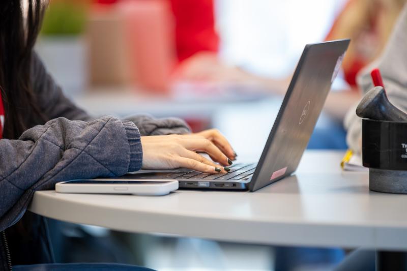 Student typing on a laptop