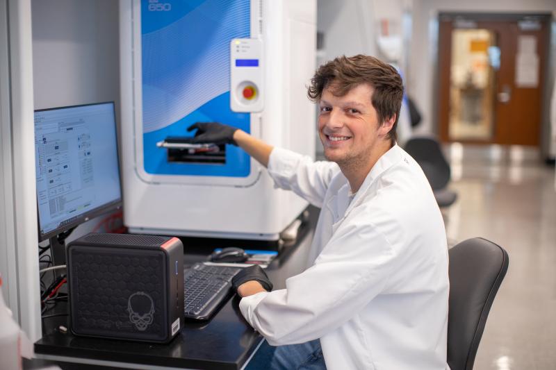 person sitting and staring at the camera near research equipment