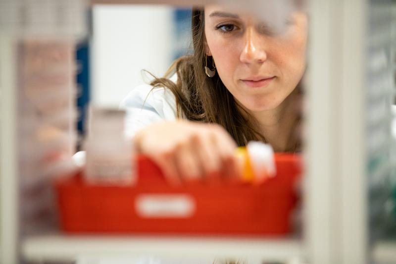 a pharmacist reaching for medication
