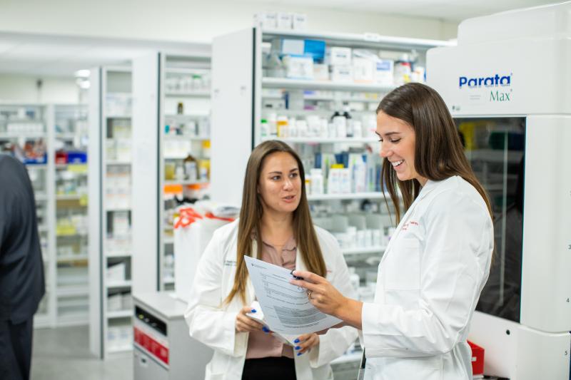 Two female pharmacists standing in pharmacy