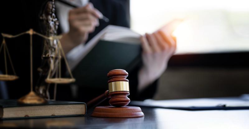 a person's desk with court hammer and justice scale