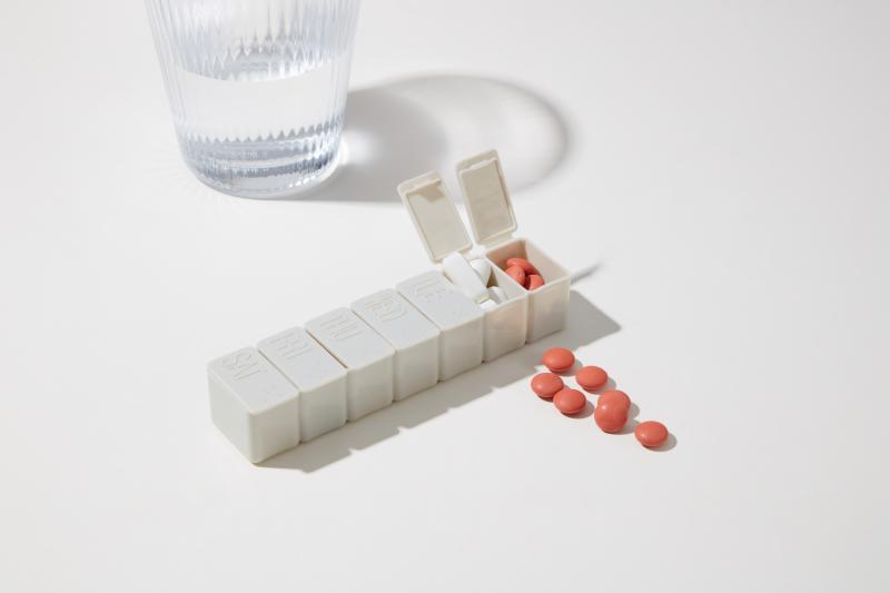 a pill organizer and glass of water