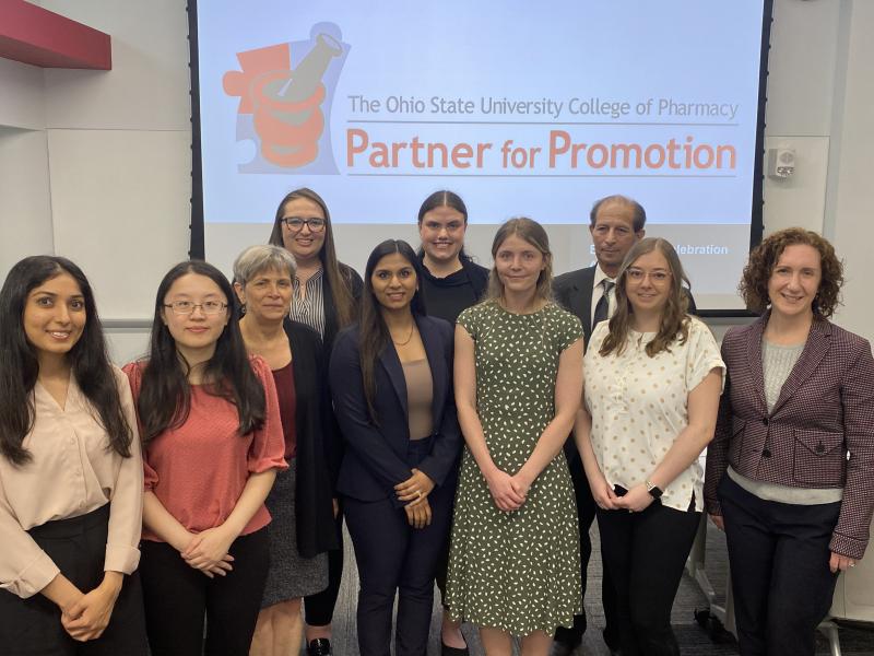 a group of people standing in front of a projector screen