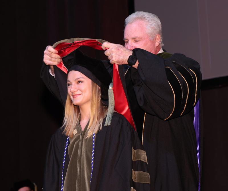 Dean Mann hooding a PharmD student