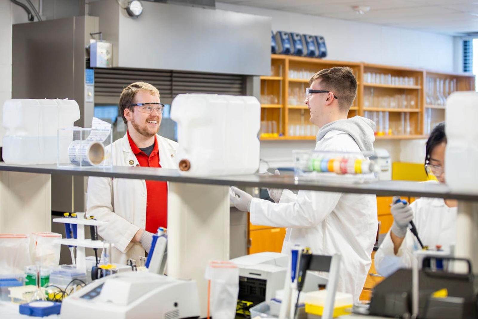 Dr. Denton speaking with a student in lab