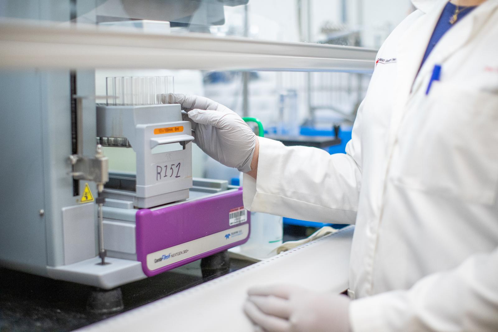 Lab researcher handling materials in a fume hood