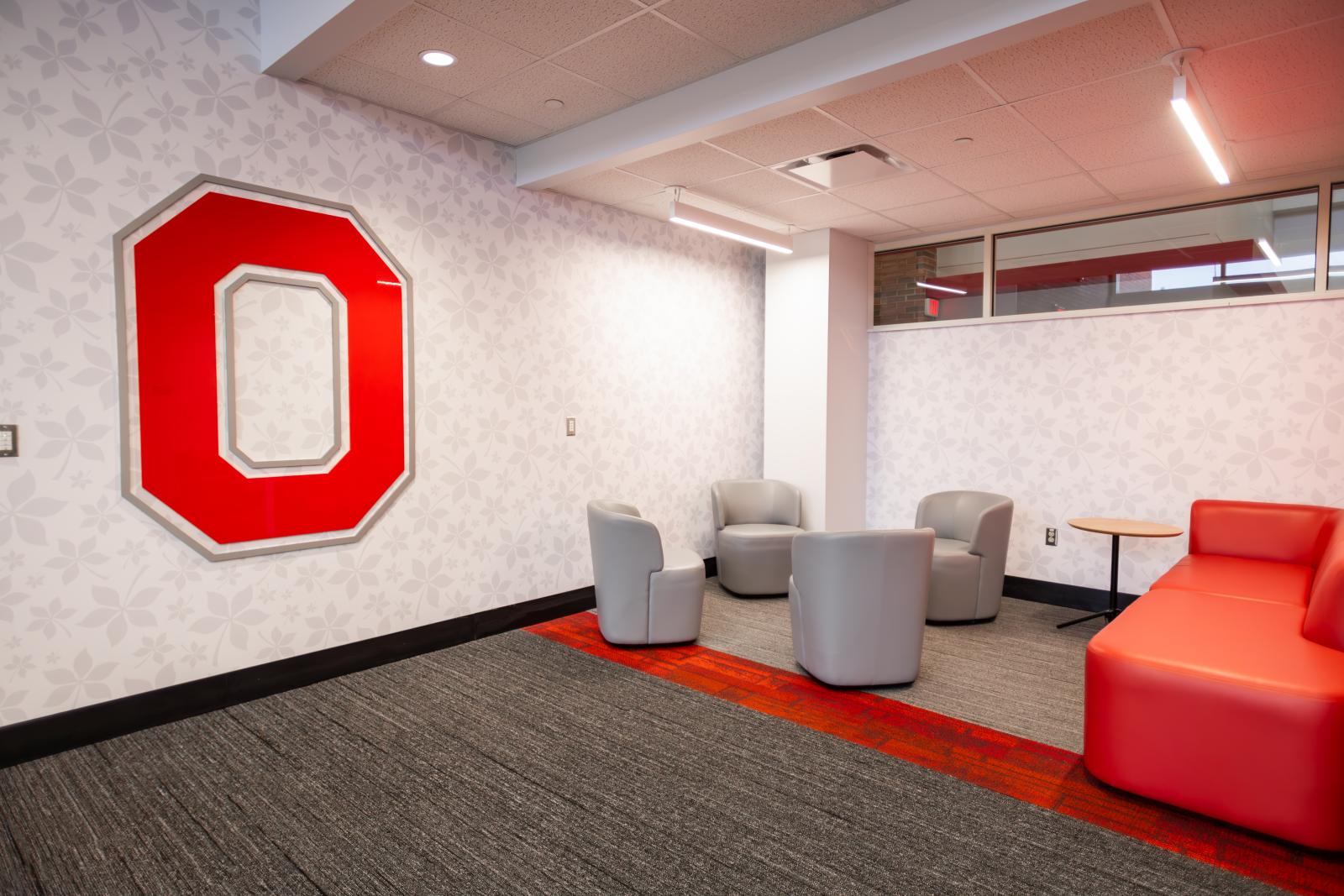 a collaboration space with lounge seating and a block o on the wall