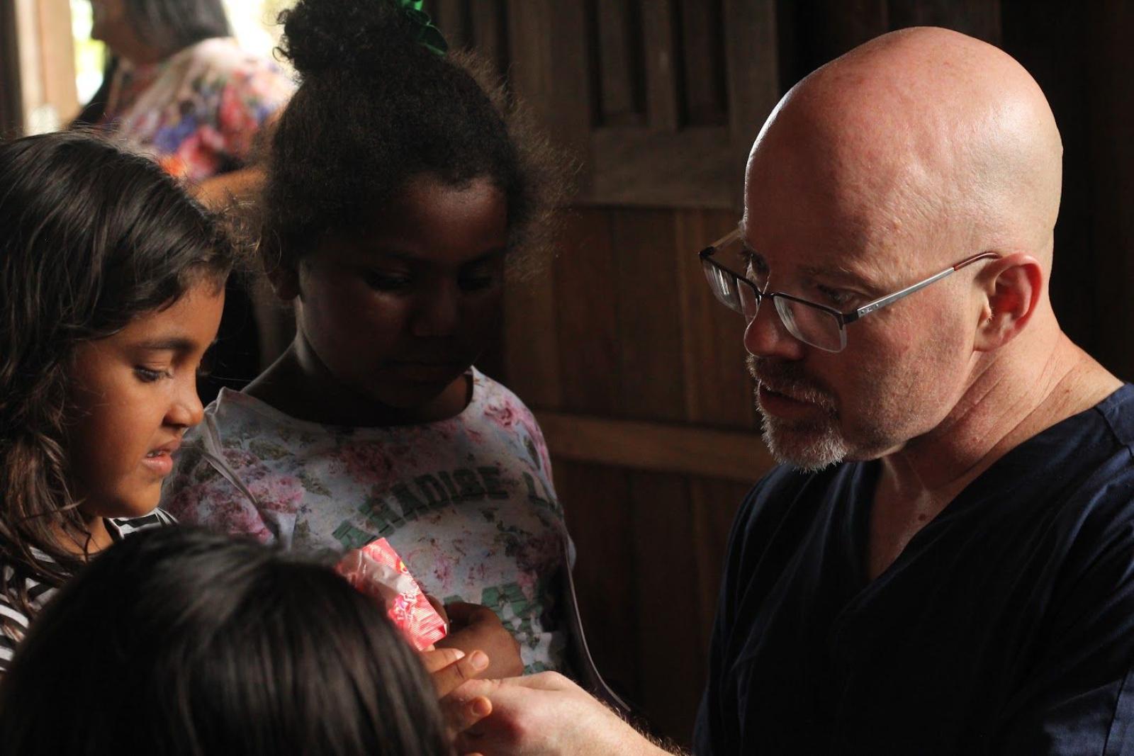 Dr. Vick speaking with children while providing medical care