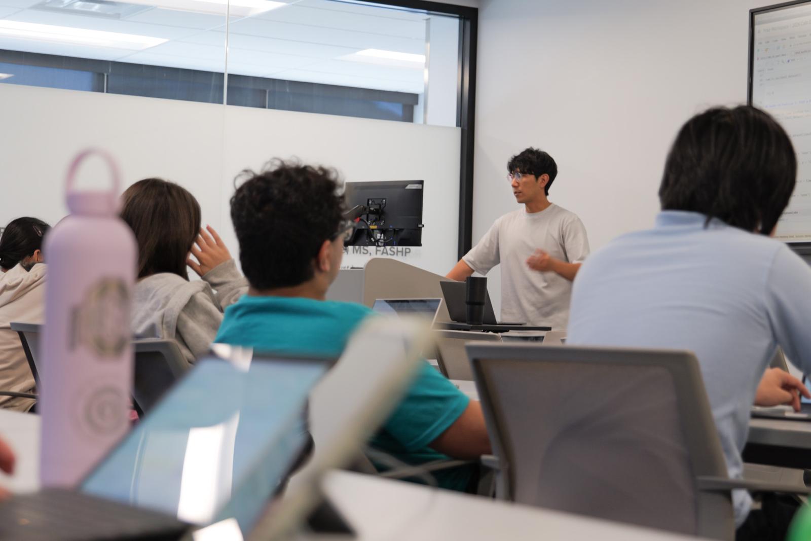 someone lecturing at a podium before a class