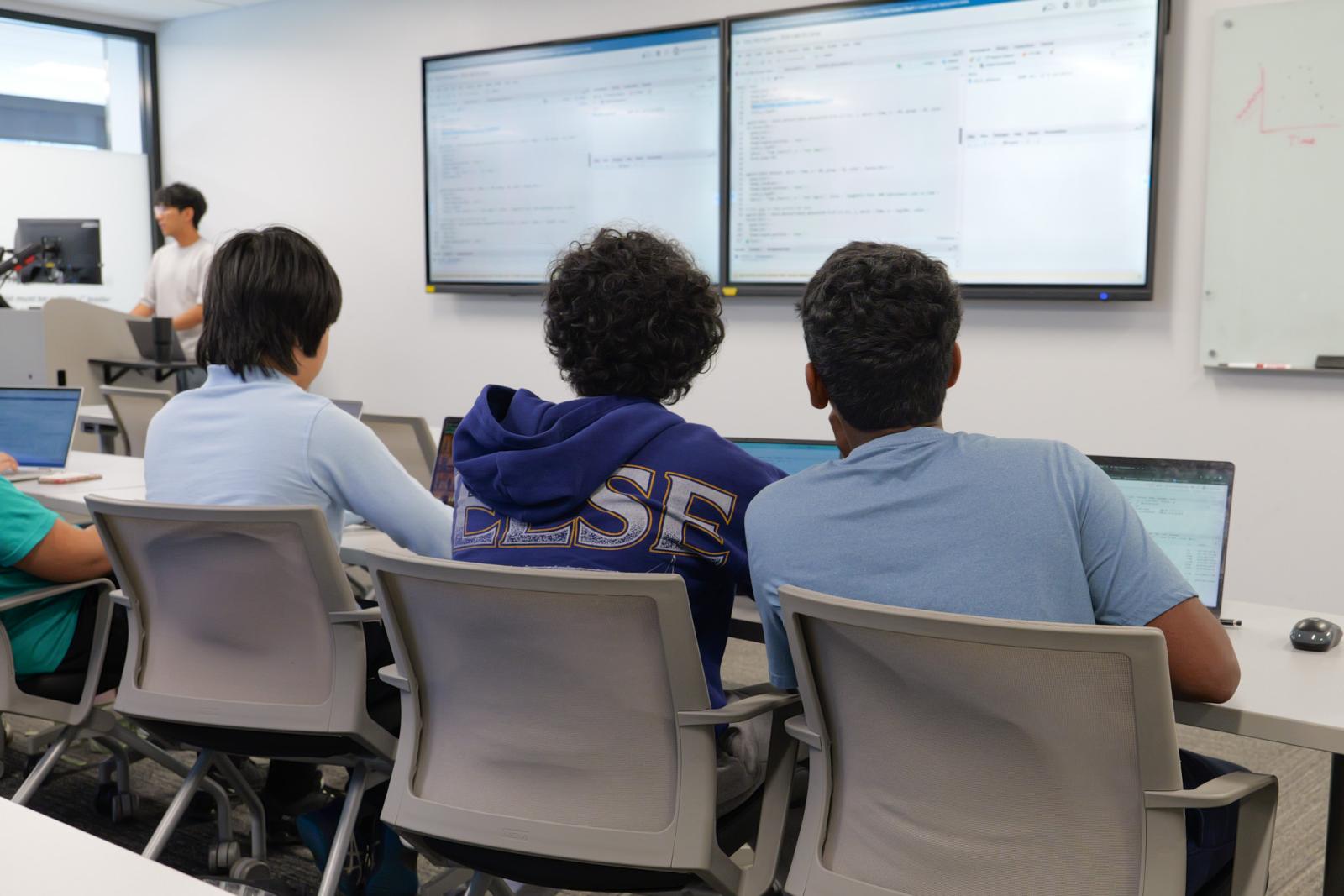 Two students looking at projected programming