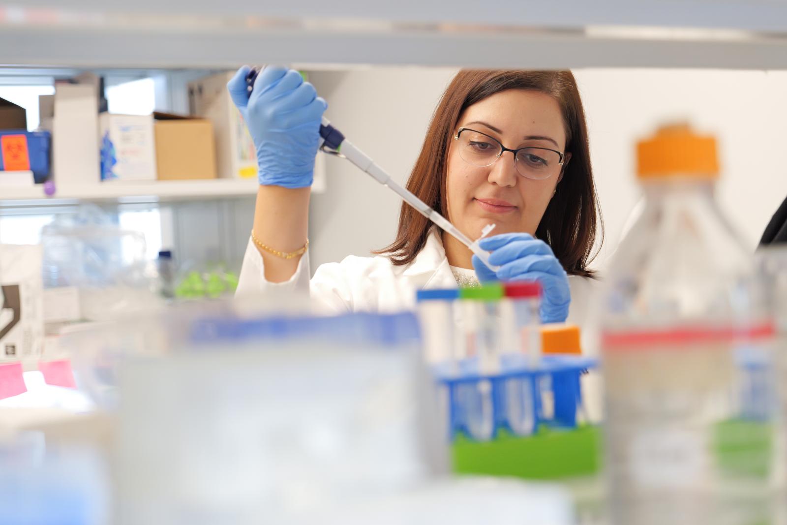 Nadeen Anabtawi using a pipette to transfer liquid into a lab capsule container