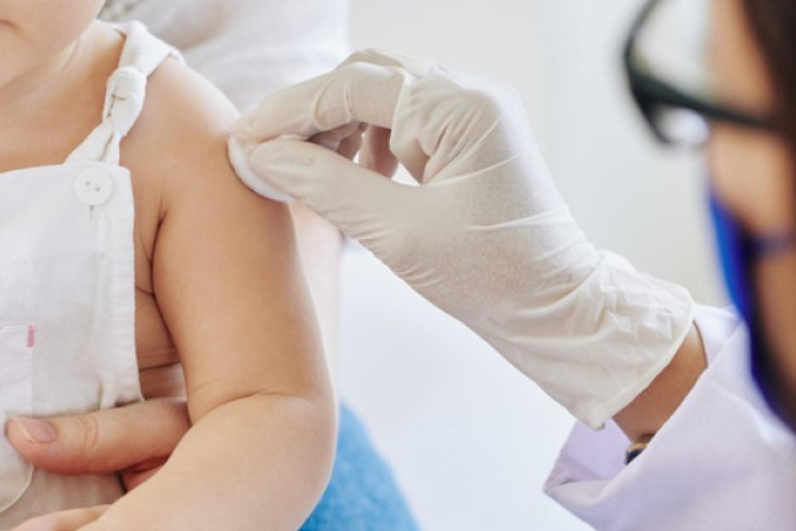 Pediatric pharmacist prepping patient for vaccine