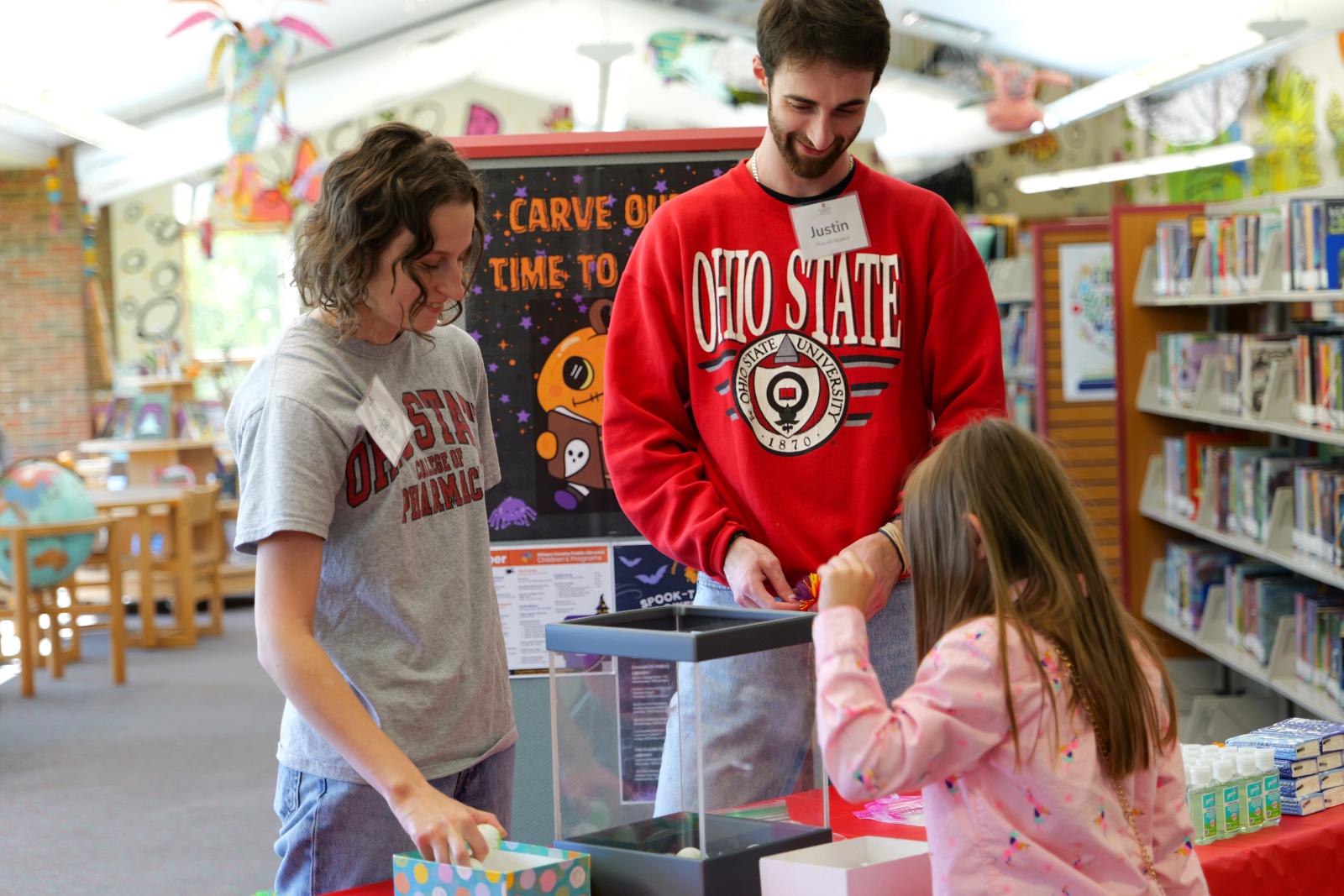 PharmD students lead a library patron through a vaccine-learning game at Athens Public Library