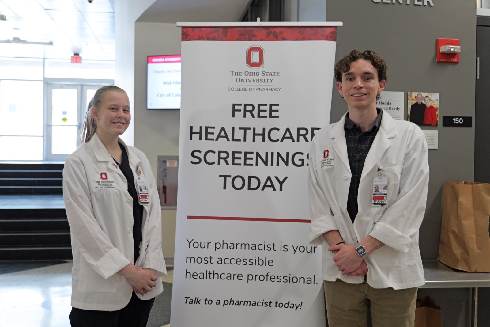 Students standing in front of "Free Healthcare Screening Today" sign