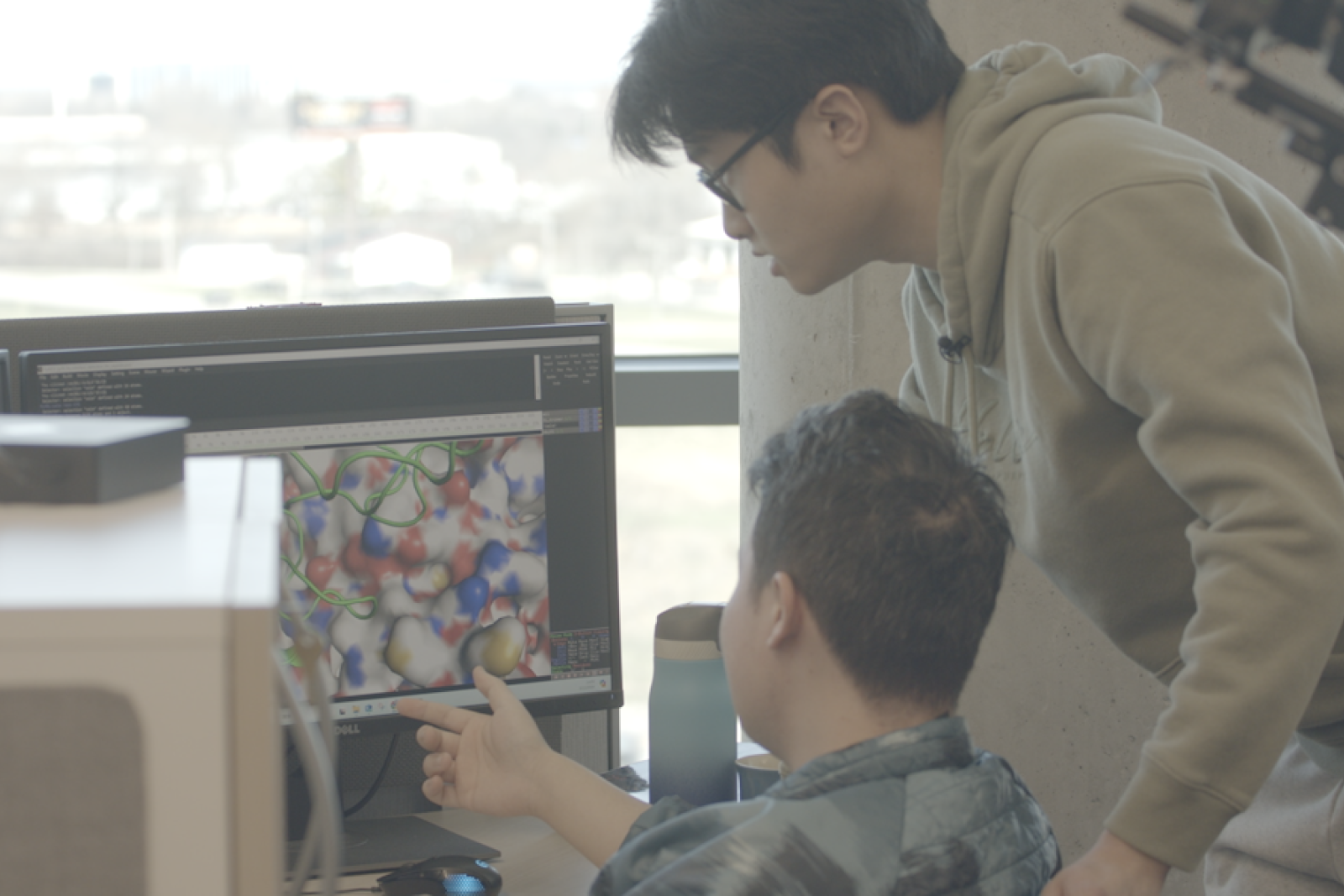 two researchers looking at a computer screen