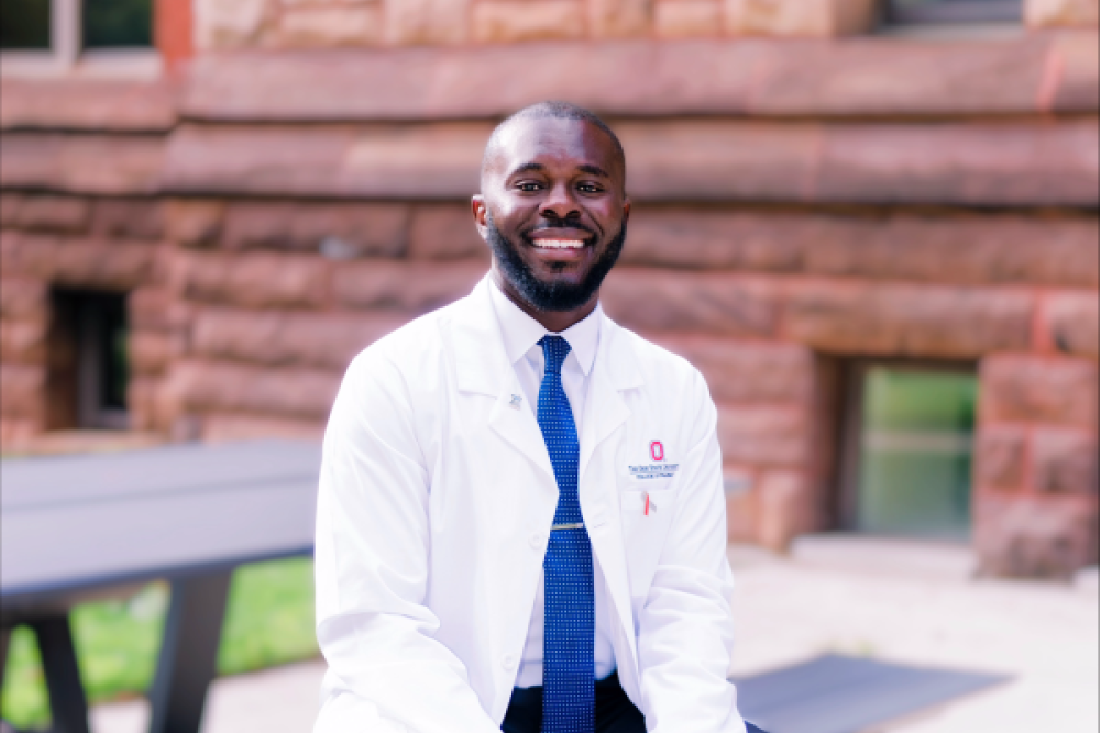 Clinton Osei sitting at a picnic table on the oval