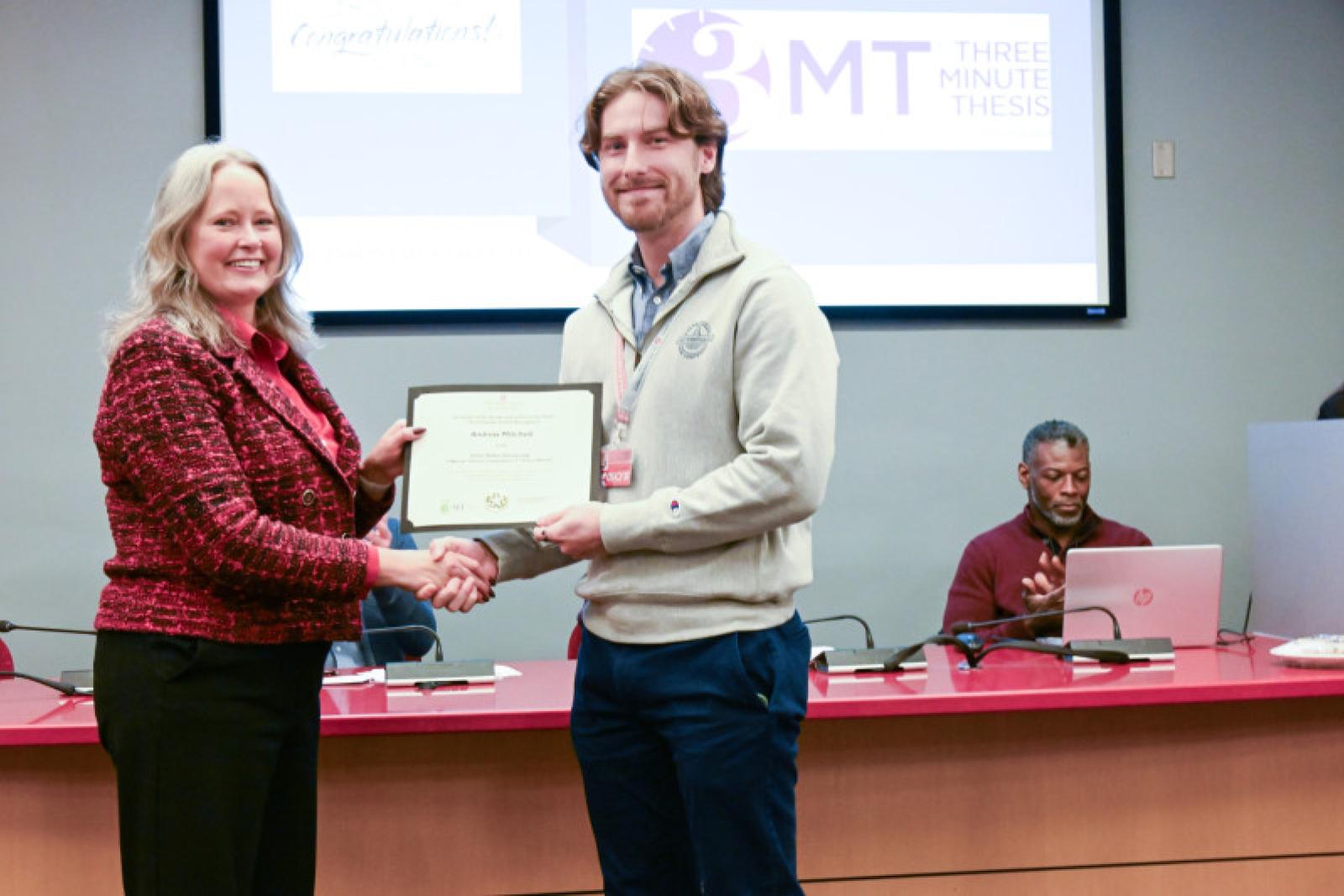 Andrew Mitchell receives the first-please award from Dean Stromberger, PhD