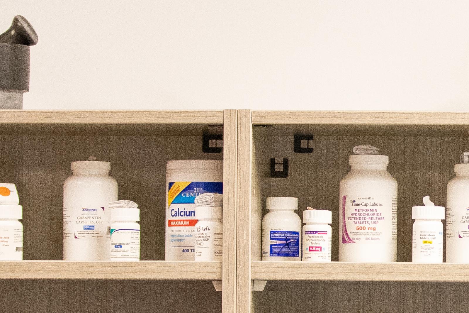Pharmacy shelves with pill bottles and "The Ohio State University" mortar and pestles